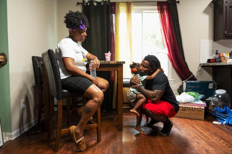 John, Mika and Esrael Roddy share a loving moment at their home. Zachary Linhares/The Kansas City Star