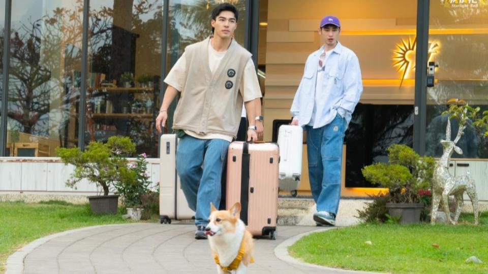 陳昊森（左）、章廣辰幫客人拿行李，店狗短短在前面帶路。（圖／TVBS）