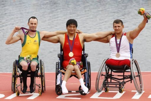 China's Cheng Huang (C) celebrates winning the gold medal in the AS men single sculls with silver medallist Australia'a Erik Horrie (L) and bronze medallist Russia's Aleksey Chuvashev during the London 2012 Paralympic Games