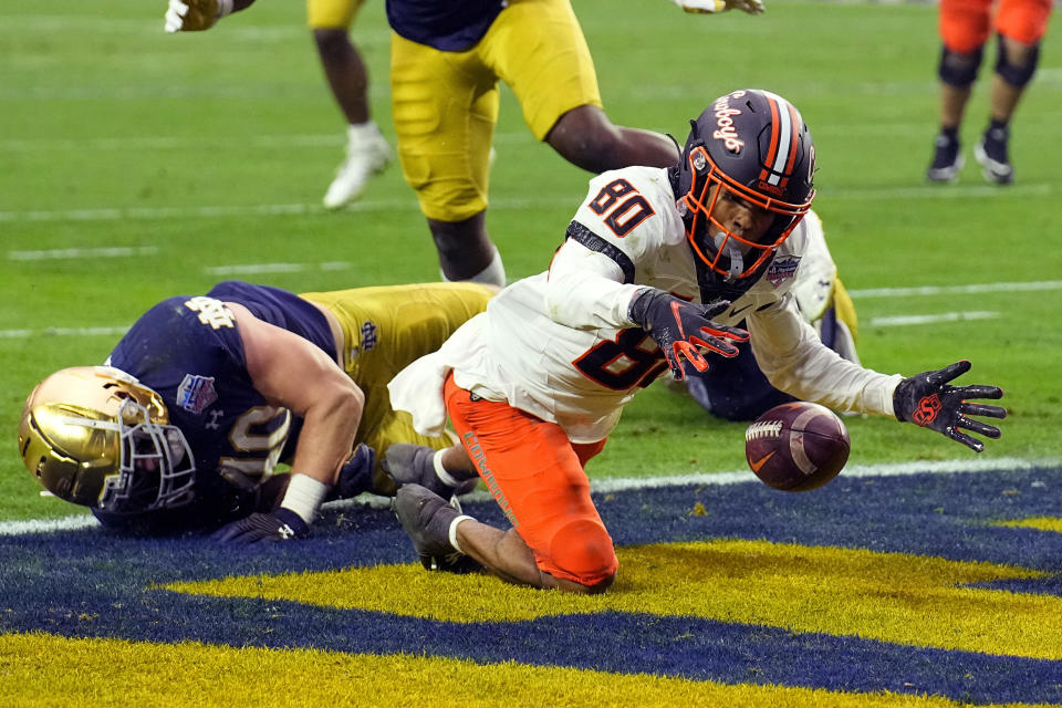 Oklahoma State wide receiver Brennan Presley (80) fumbles the football at the goal line as Notre Dame linebacker Drew White (40) defends during the second half of the Fiesta Bowl NCAA college football game, Saturday, Jan. 1, 2022, in Glendale, Ariz. Notre Dame recovered the ball. (AP Photo/Rick Scuteri)