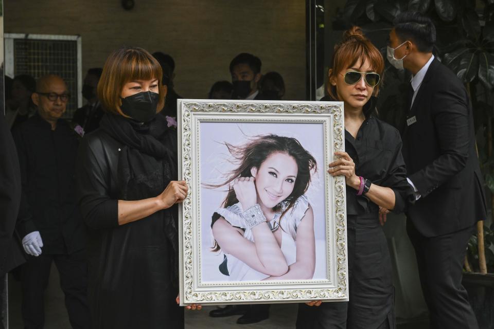 Relatives hold a photo of Coco Lee after her funeral in Hong Kong, Tuesday, Aug. 1, 2023. Lee was being mourned by family and friends at a private ceremony Tuesday a day after fans paid their respects at a public memorial for the Hong Kong-born entertainer who had international success. (AP Photo/Billy H.C. Kwok)