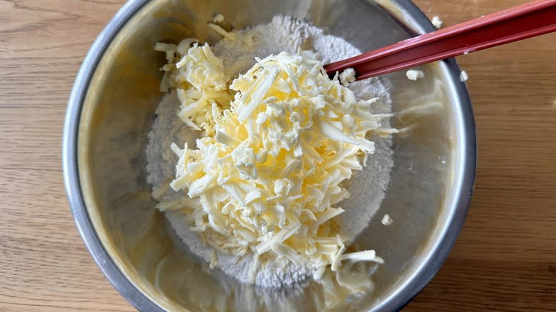 grated butter going into bowl