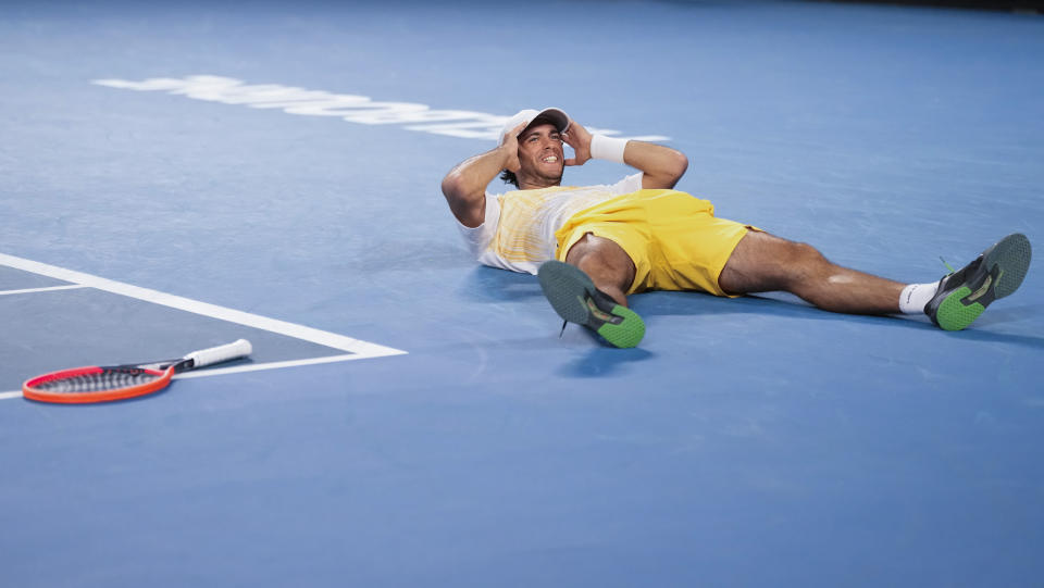 Nuno Borges of Portugal lies on the court after defeating Grigor Dimitrov of Bulgaria in their third round match at the Australian Open tennis championships at Melbourne Park, Melbourne, Australia, Saturday, Jan. 20, 2024. (AP Photo/Alessandra Tarantino)