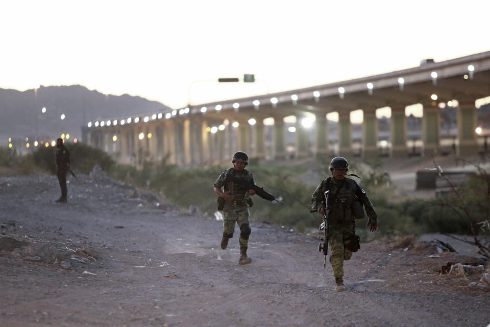 Military police wearing the insignia of the new National Guard run to detain Guatemalan migrants to keep them from crossing the Rio Grande from Ciudad Juarez, Mexico, to El Paso, Texas, Monday, June 24, 2019. (AP Photo/Christian Chavez)