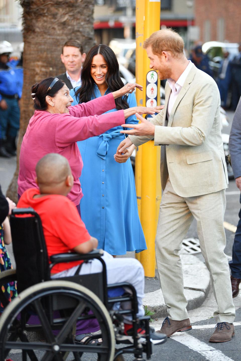 Somaya Ebrahim, 81, a former District Six resident who was in the crowds when the Queen visited the town in 1947 with her parents and sister Princess Margaret, jumped in Harry’s arms for a big hug as they walked by. She then excitedly hugged Meghan as she asked them: “<a href="https://people.com/royals/meghan-markle-prince-harry-response-fan-asks-where-archie-royal-tour/" rel="nofollow noopener" target="_blank" data-ylk="slk:Where's Archie?;elm:context_link;itc:0;sec:content-canvas" class="link ">Where's Archie?</a>" Harry told her, “He’s sleeping.”