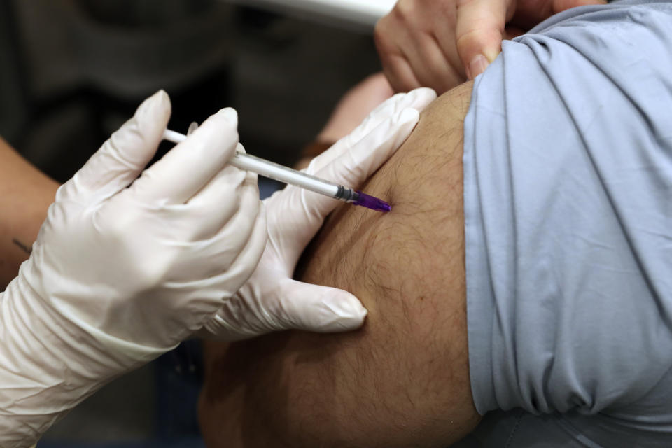 A healthcare worker receives Pfizer-BioNTech COVID-19 vaccine during a nationwide vaccination program at the American University Medical Center in Beirut, Lebanon, Sunday, Feb. 14, 2021. (AP Photo/Bilal Hussein)