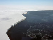 <p>The Getz Ice Shelf extends several miles into the ocean from the Getz Glacier as it empties into the ocean along the Antarctic coast, Nov. 5, 2010. The vertical face of the ice shelf is almost 200 feet high and is estimated to extend another 1000 feet below the ocean surface. (Photo: NASA/Dick Ewers) </p>