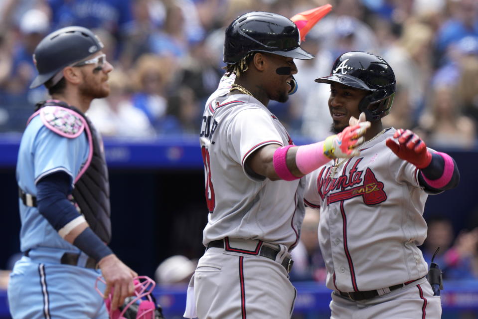 Atlanta Braves' Ozzie Albies, right, celebrates his two-run home run with Ronald Acuna Jr. as Toronto Blue Jays catcher Danny Jansen looks on during the third inning of a baseball game in Toronto, on Sunday, May 14, 2023. (Frank Gunn/The Canadian Press via AP)