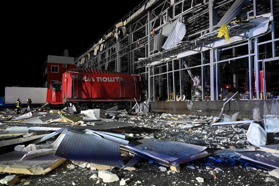 Ukrainian rescuers working among the debris of a mail depot building following missile strikes at the village of Korotych in Kharkiv region on Saturday (AFP via Getty Images)