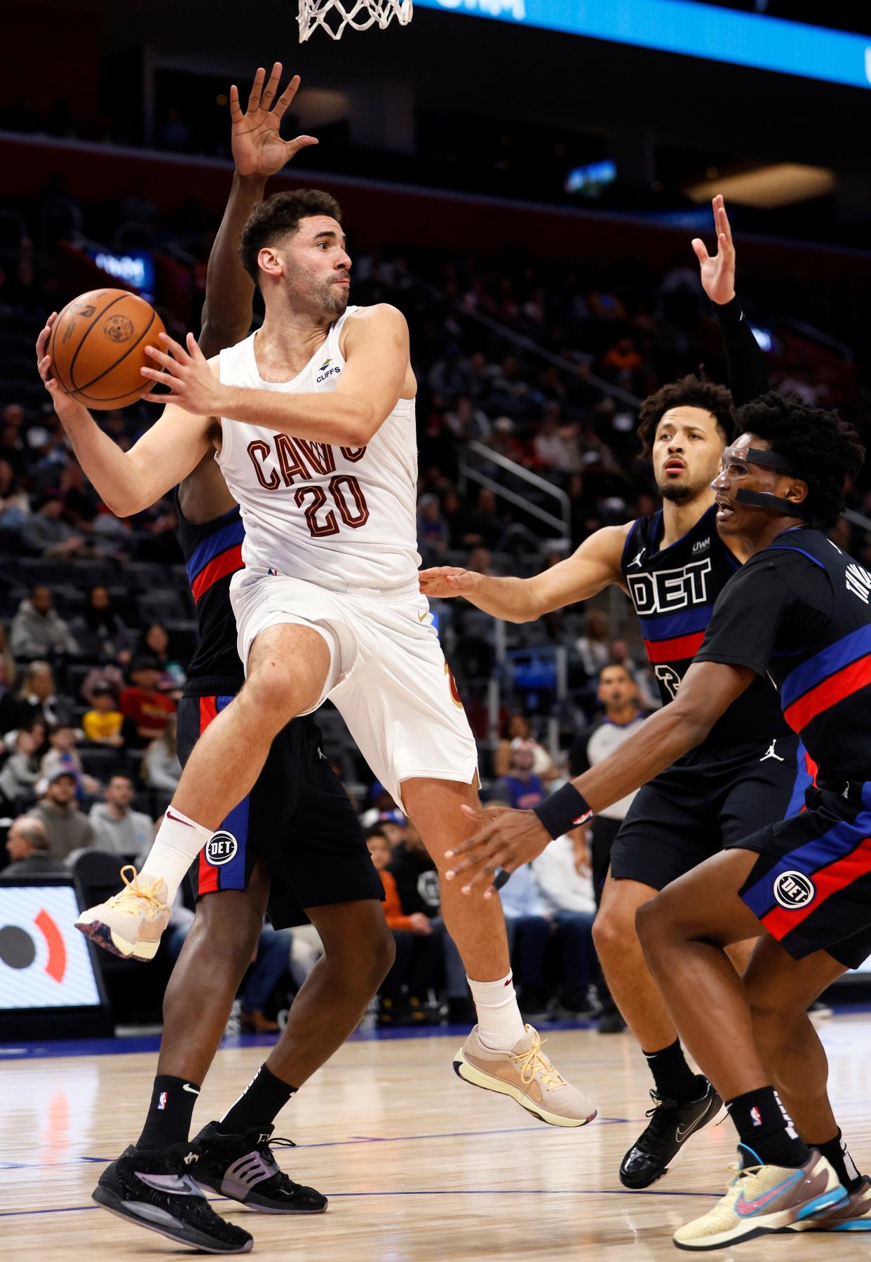 Cleveland Cavaliers forward Georges Niang looks to pass the ball while pressured by Detroit Pistons center Jalen Duren, guard Cade Cunningham, and forward Ausar Thompson, during the second half at Little Caesars Arena in Detroit on Dec. 2, 2023