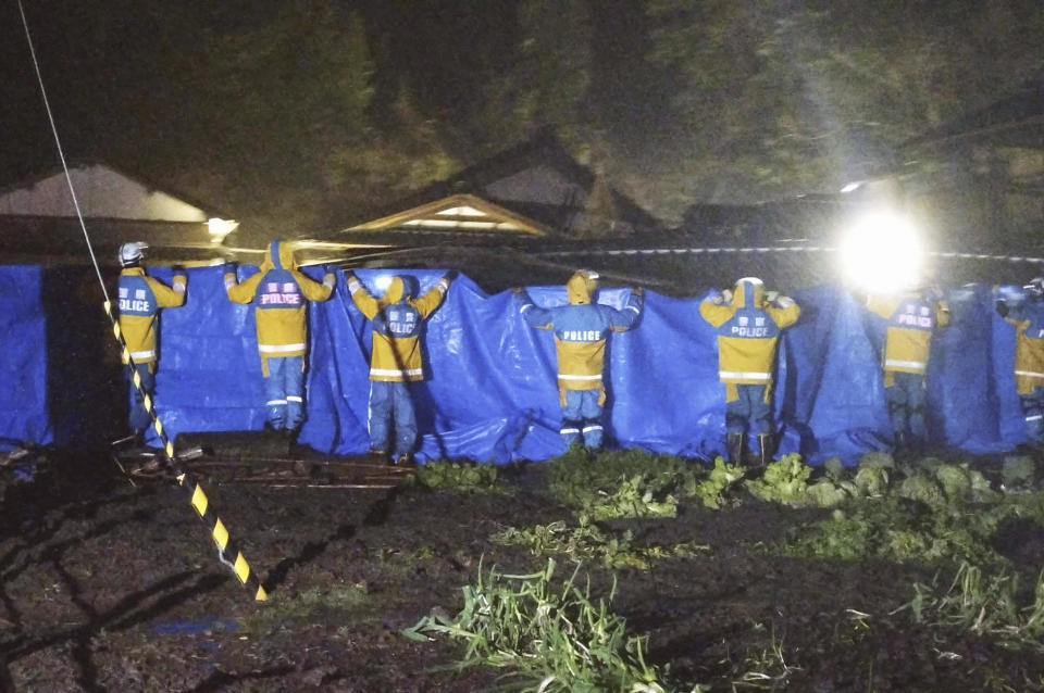 Police officers use blue sheets as a woman in 90s is rescued alive from a collapsed house in Suzu, Ishikawa prefecture, Japan Saturday, Jan. 6, 2024, more than 120 hours after a series of powerful quakes started rattling Japan’s western coast. (Kyodo News via AP)