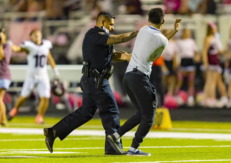 Bastrop police remove the lawn mower prankster from the field and later arrested him in the third quarter of the Cedar Creek-Bastrop game Friday at Bastrop Memorial Stadium.