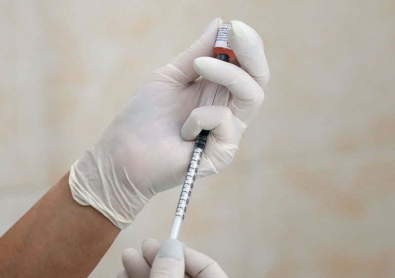 FILE PHOTO: A nurse fills a syringe with a vaccine before administering an injection at a children's clinic in Kiev