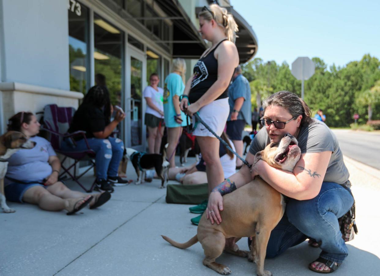 Kerri Cogen hugs Biggamon during a Renegade Paws adoption event outside of Bentley's in Pooler. Cogen was out meeting new dogs for the first time since her dog passed away.