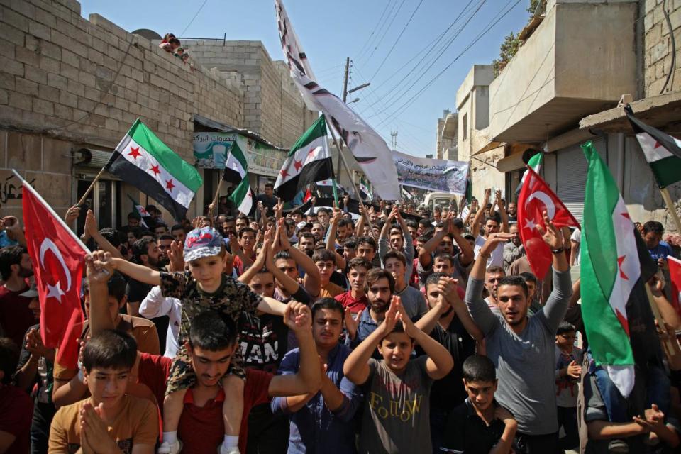 Syrians chant slogans and wave flags of the opposition and of Turkey during demonstration against the Assad regime yesterday, in the rebel-held town of Hazzanu, northwest of Idlib. (AFP/Getty/Aeref Watad)