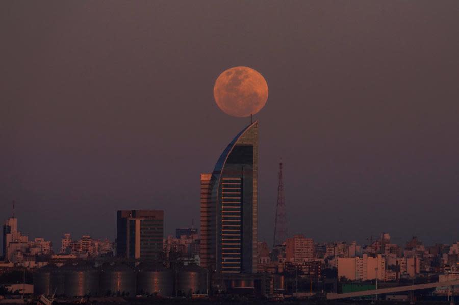 A supermoon rises over Montevideo, Uruguay, Wednesday, Aug. 30, 2023. The cosmic curtain rose Wednesday night with the second full moon of the month, also known as a blue moon. (AP Photo/Matilde Campodonico)