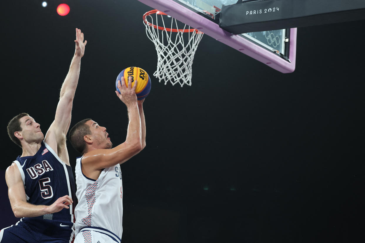 US' #05 Jimmer Fredette (L) tries to block Serbia's #09 Mihailo Vasic in the men's pool round 3x3 basketball game between Serbia and the USA during the Paris 2024 Olympic Games at La Concorde in Paris on July 30, 2024. (Photo by David GRAY / AFP) (Photo by DAVID GRAY/AFP via Getty Images)