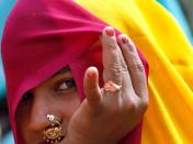 A Hindu woman looks on after taking a ritualistic dip in the Ganges River during the Kumbh Mela in Haridwar, India, Wednesday, Feb. 10, 2010. The Kumbh Mela, touted as the largest religious gathering in the world, is celebrated every three years, rotating among four Indian cities (AP Photo/ Rajesh Kumar Singh)