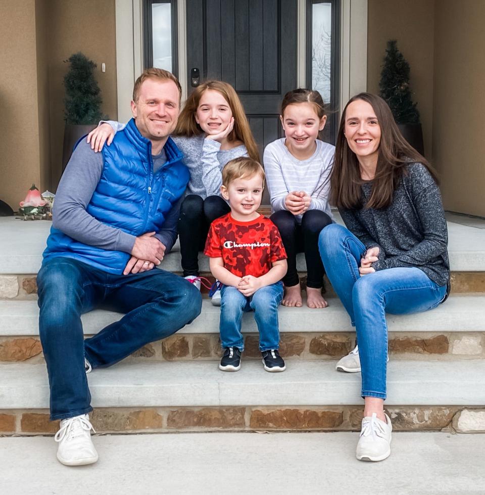 Aaron Johnson (left) and Ashlee Johnson (right) pose for a photo with their children Ailee, Aspyn and Aden.