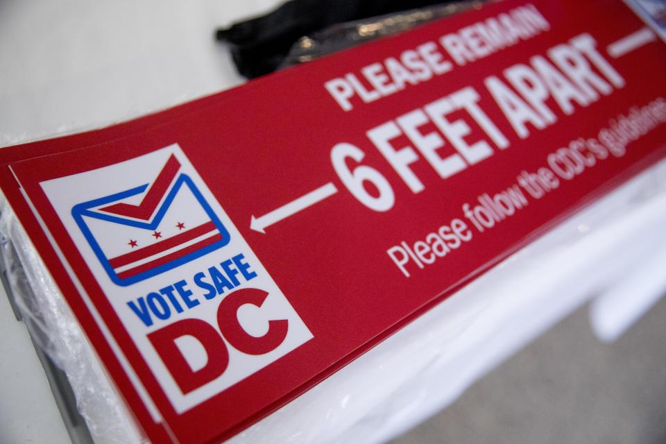 Social distancing stickers are visible at a voting center during primary voting in Washington, Tuesday, June 2, 2020. (AP Photo/Andrew Harnik)