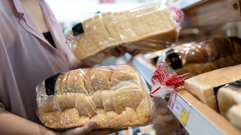 Woman checking sliced fresh bread in plastic bags