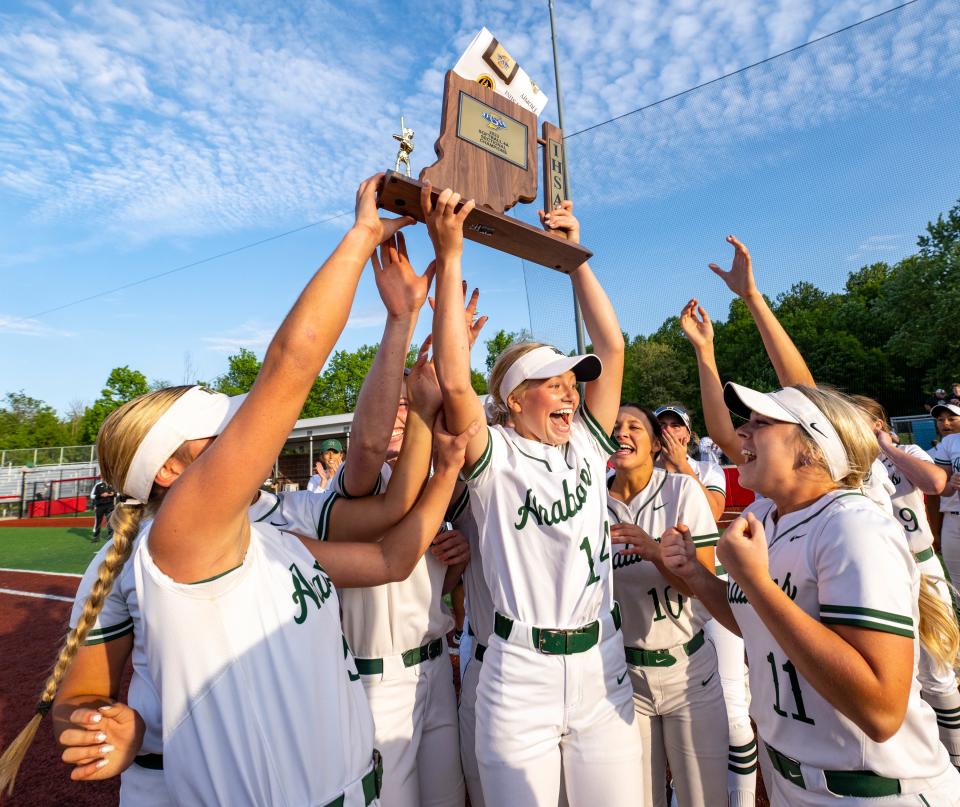 Pendleton Heights High School senior Lillian Coffel (14), center, celebrates with her teammates and the trophy after winning a IHSAA Class 4A Softball Sectional Championship game against New Palestine High School, Thursday, May 25, 2023, at New Palestine High School.