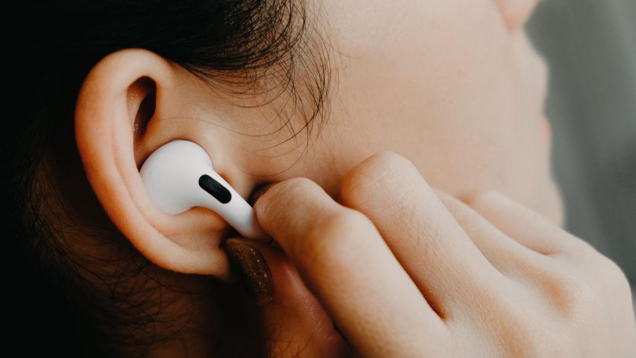  Close-up of woman using AirPods Pro 2. 