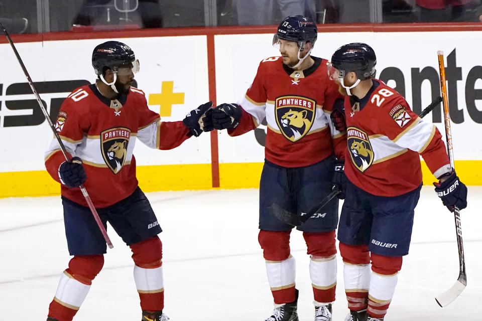 Florida Panthers center Sam Reinhart, center is congratulated by left wing Anthony Duclair (10) ands right wing Claude Giroux (28) after scoring a goal against the Tampa Bay Lightning during the third period of an NHL hockey game, Sunday, April 24, 2022, in Sunrise, Fla. The Lightning won 8-4. (AP Photo/Lynne Sladky)