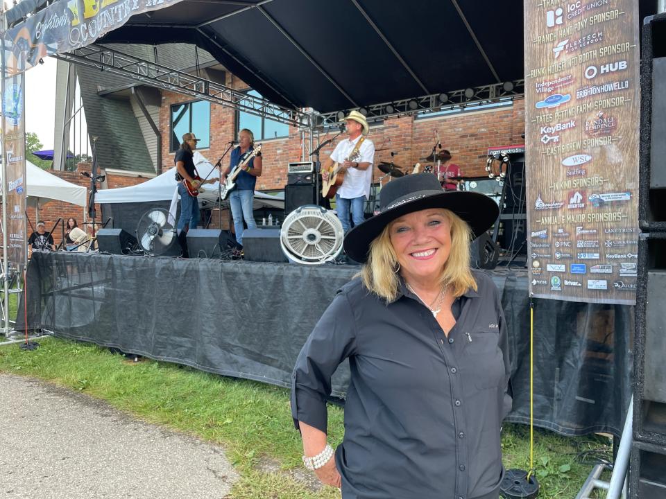 Pam McConeghy, president and CEO of the Greater Brighton Area Chamber of Commerce, stands near the stage as Shiatown performs at the Yellowstone Country Music Festival at Mt. Brighton on July 22, 2023.