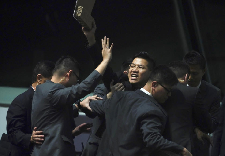 Pro-democracy lawmaker Gray Fan, center, is taken away as he shouts a slogan while Hong Kong Chief Executive Carrie Lam arrives at chamber of the Legislative Council in Hong Kong, Thursday, Oct. 17, 2019. (AP Photo/Vincent Yu)