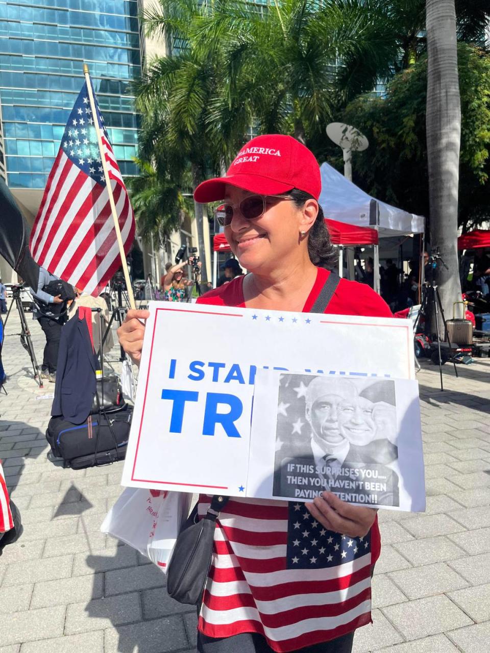 Esperanza Juan, 59, waves signs in support of former President Donald Trump outside Miami’s federal courthouse on Tuesday, June 13, 2023.