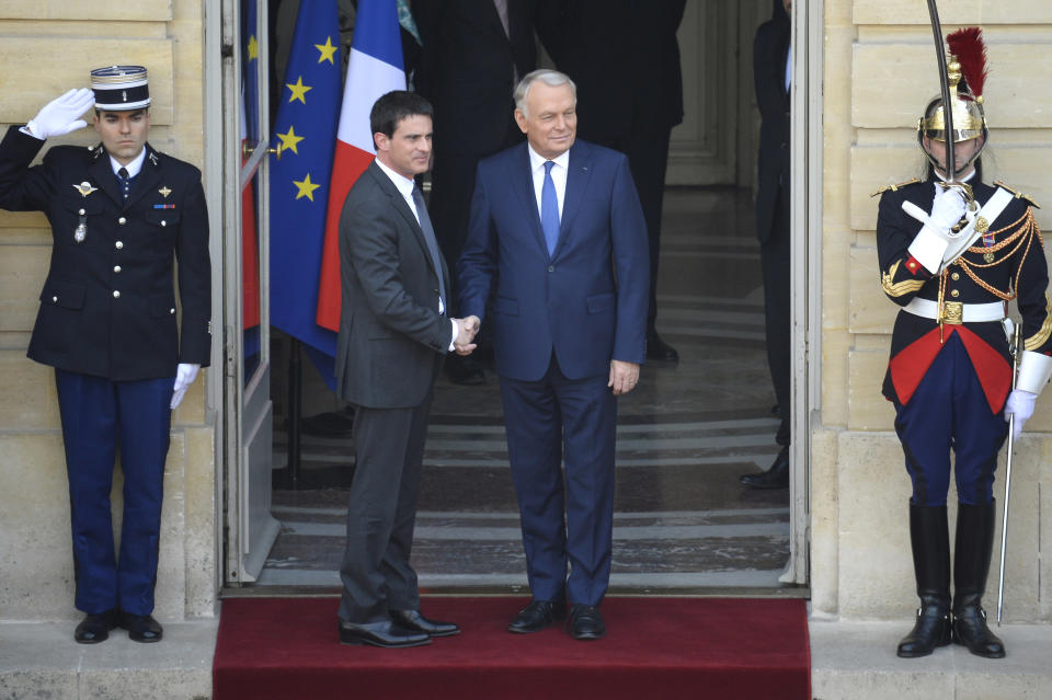 Outgoing French Prime Minister Jean-Marc Ayrault, right, shakes hands with incoming French Prime Minister Manuel Valls, during the takeover ceremony at the Prime Ministry in Paris, Tuesday, April 1, 2014. France's new prime minister is taking office after Socialist President Francois Hollande named Valls on Monday as prime minister. (AP Photo/Lionel Bonaventure, Pool)