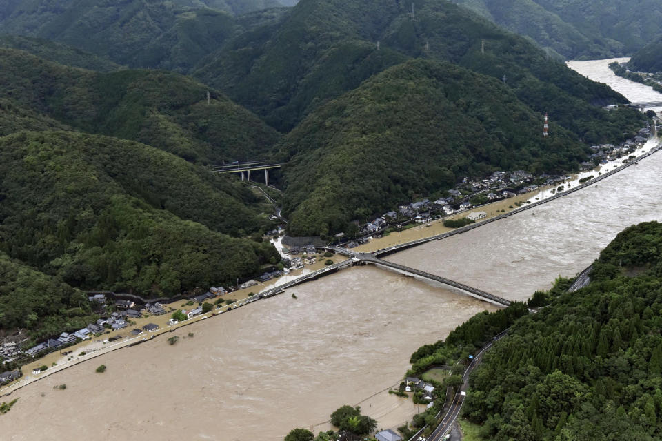 This aerial view shows the Kuma River flooded with heavy rain in Yatsushiro, Kumamoto prefecture, southwestern Japan, Saturday, July 4, 2020. The Japan Meteorological Agency raised the heavy rain warnings in many parts of the prefectures to the highest level shortly before 5 a.m. It was the first time for the agency to do so in the two prefectures, Kumamoto and Kagoshima. (Kyodo News via AP)