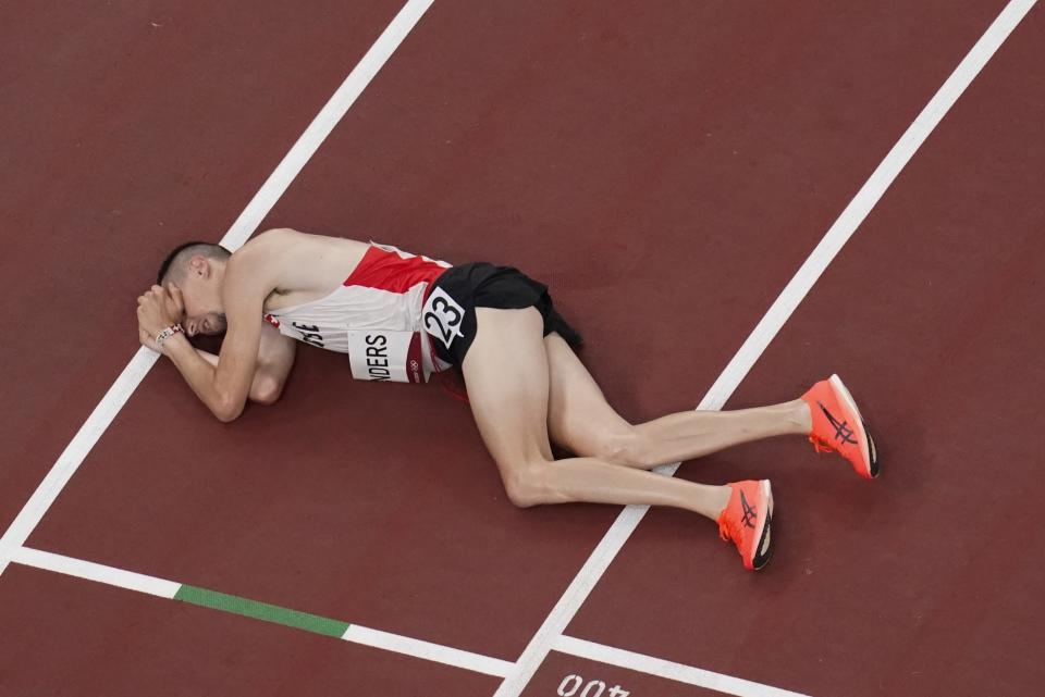 Julien Wanders, of Switzerland, collapses after running in the men's 10,000-meter finals at the 2020 Summer Olympics, Friday, July 30, 2021, in Tokyo. (AP Photo/Morry Gash)