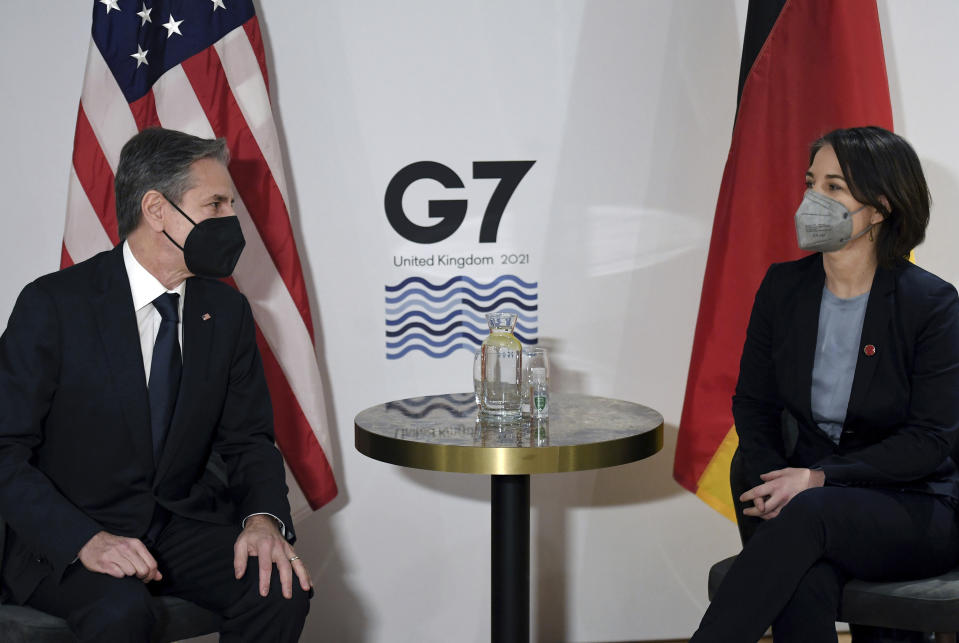 US Secretary of State Antony Blinken, left, and Germany's Foreign Minister Annalena Baerbock, wearing face coverings to combat the spread of the coronavirus, pose for a photograph before a bilateral meeting ahead of the G7 foreign ministers summit in Liverpool, England, Friday, Dec. 10, 2021. Blinken arrived in Britain for a G7 ministers' meeting before visiting Indonesia, Malaysia and Thailand. (Olivier Douliery/Pool Photo via AP)