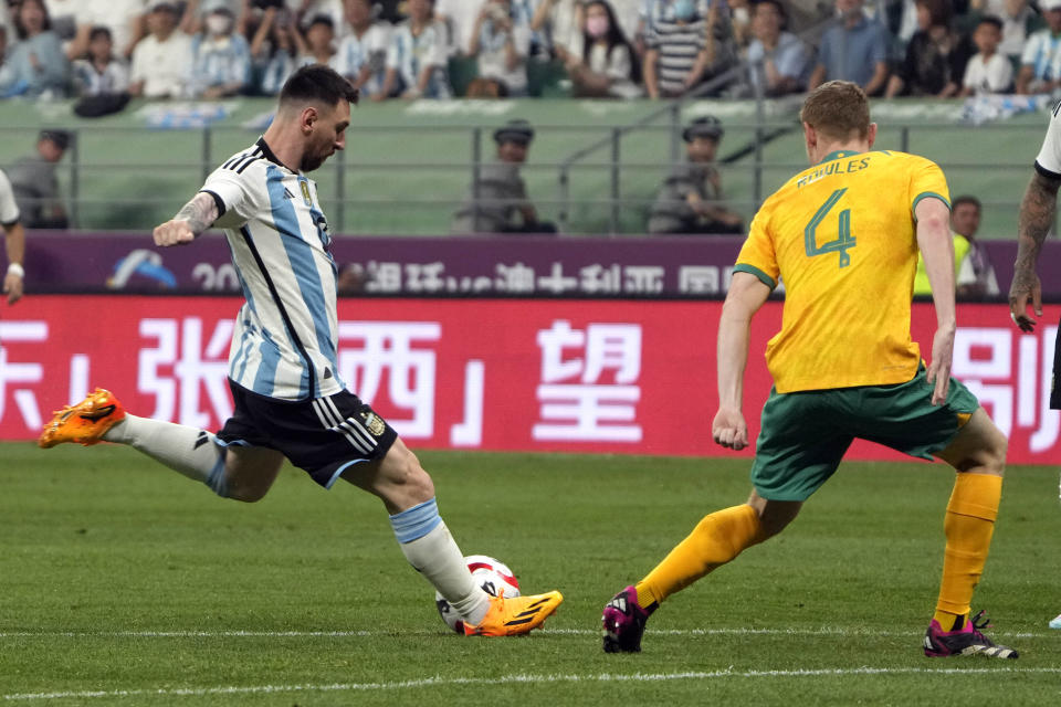 Argentina's Lionel Messi, left, scores a goal past Australia's Kye Rowles during the first half of their friendly soccer match at Workers' Stadium in Beijing, Thursday, June 15, 2023. (AP Photo/Mark Schiefelbein)