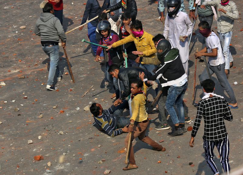 A man is beaten during a clash between people supporting a new citizenship law and those opposing the law in New Delhi