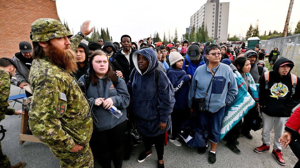 People line up outside a school to be evacuated in Yellowknife.      - Jennifer Gauthier/Reuters