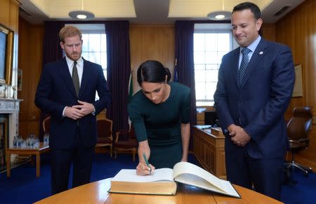 Britain's Prince Harry and his wife Meghan, the Duke and Duchess of Sussex, sign the visitors book in the office of the Taoiseach Leo Varadkar, at the start of a two-day visit to Dublin, Ireland July 10, 2018. REUTERS/Clodagh Kilcoyne