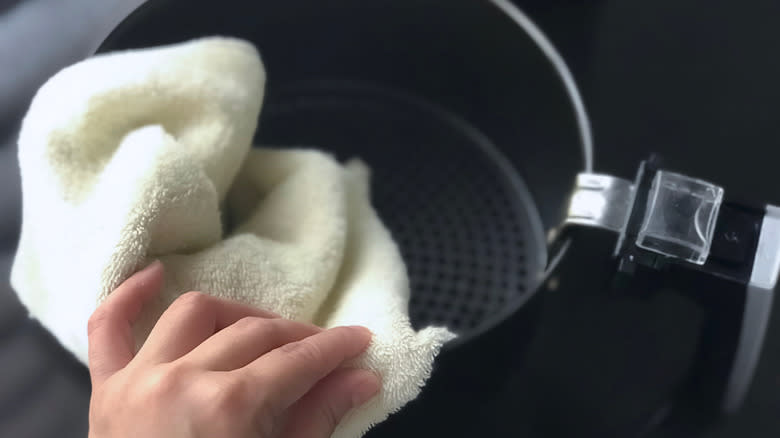 Scrubbing air fryer with cloth