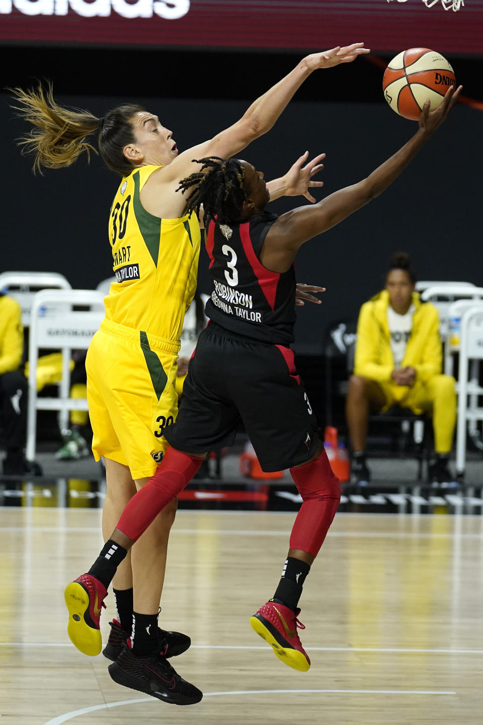 Las Vegas Aces guard Danielle Robinson (3) shoots as she is guarded by Seattle Storm forward Breanna Stewart (30) during the first half of Game 1 of basketball's WNBA Finals Friday, Oct. 2, 2020, in Bradenton, Fla. (AP Photo/Chris O'Meara)