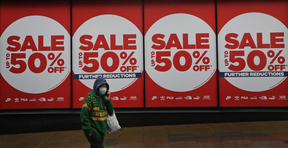 A woman wearing a face covering walks past a shop window in London, Thursday, Jan. 14, 2021 during England's third national lockdown to curb the spread of coronavirus. (AP Photo/Kirsty Wigglesworth)