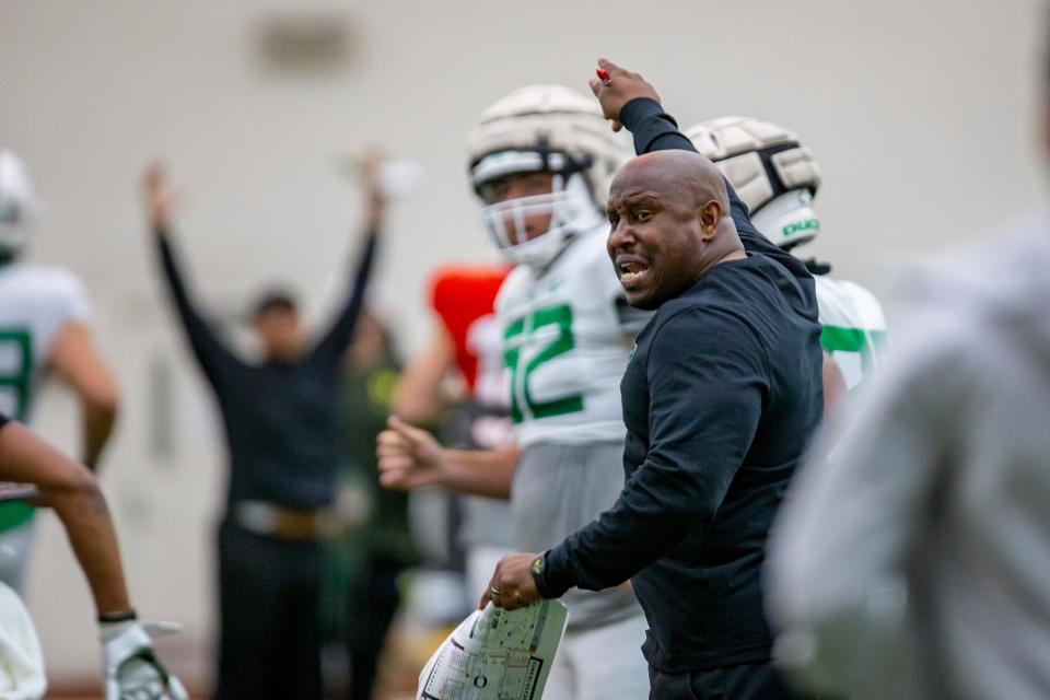 Oregon running backs coach Carlos Locklyn calls to players Tuesday, April 12, 2022, at practice with the Ducks in Eugene. 