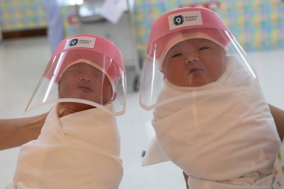 Nurses hold newborn babies wearing protective face shields during the coronavirus disease (COVID-19) outbreak at the Praram 9 hospital in Bangkok, Thailand, April 9, 2020.
