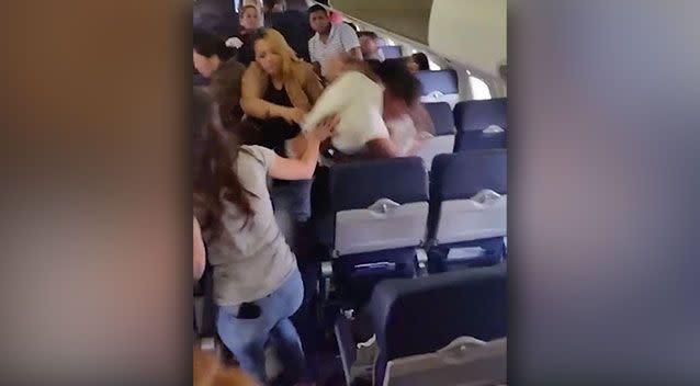 Passengers try to break up the two men. Photo: Supplied