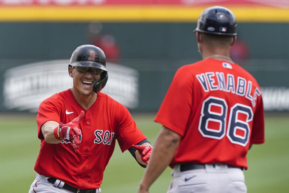 Boston Red Sox' Enrique Hernandez, left, reacts as he rounds the bases and runs towards third base coach Will Venable after hitting a home run in the third inning of Inning of a spring training baseball game against the Atlanta Braves on Monday, March 29, 2021, in North Port, Fla. (AP Photo/John Bazemore)