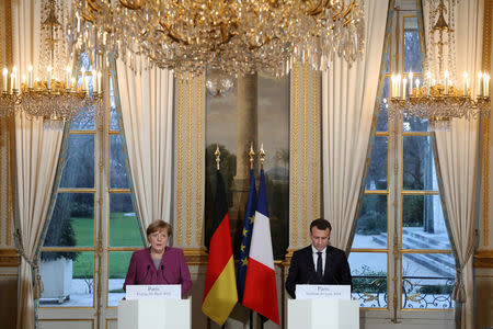 French President Emmanuel Macron (R) and German Chancellor Angela Merkel give a joint press conference at the Eylsee presidential Palace in Paris, France March 16, 2018. Ludovic Marin/Poolvia REUTERS