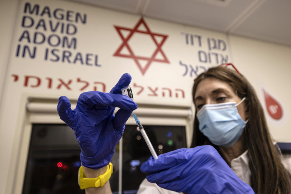 A medic from Israel’s Magen David Adom emergency service prepares a booster shot of the coronavirus vaccine in Tel Aviv on Aug. 14, 2021.