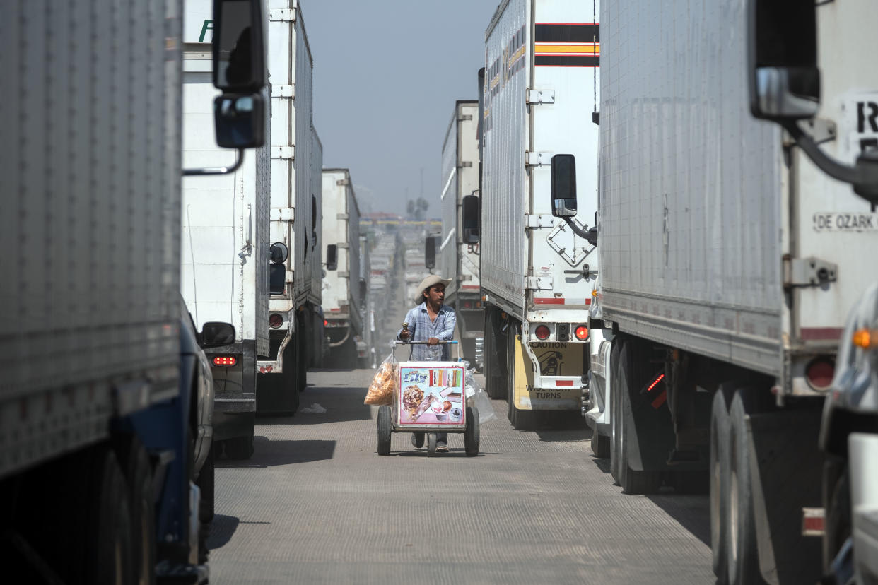 A street vendor sells ice cream to cargo trucks drivers lining up to cross to the United States at Otay commercial crossing port in Tijuana, Baja California state, on June 6, 2019, Mexico. - The US warned Mexico Thursday it needed to make more concessions on slowing migration to avoid President Donald Trump's threatened tariffs, as the Mexican leader announced he would visit the border to 