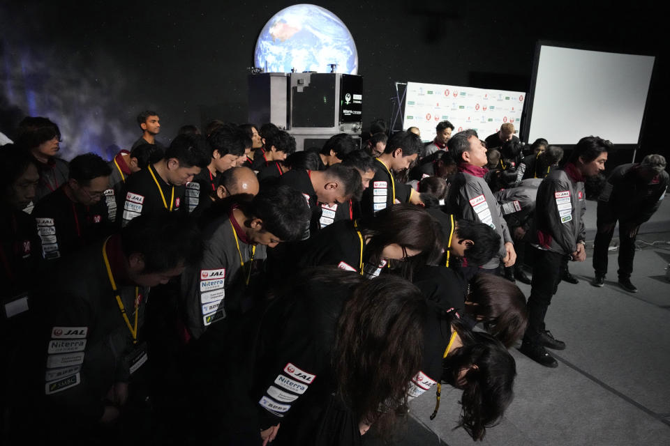 Takeshi Hakamada, founder and CEO of ispace, right, and his team staff bow at the end of livestream of HAKUTO-R private lunar exploration program on screen at the lunar landing event Wednesday, April 26, 2023, at Miraikan, the National Museum of Emerging Science and Innovation, in Tokyo. Tokyo's ispace tried to land its own spacecraft on the moon early on Wednesday, but its fate was unknown as flight controllers lost contact with it moments before the planned touchdown. (AP Photo/Eugene Hoshiko)